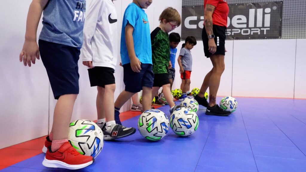 young kids learning to play soccer indoors at soccer pups facility