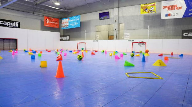 Cones, goals, and soccer balls on an indoor soccer court.